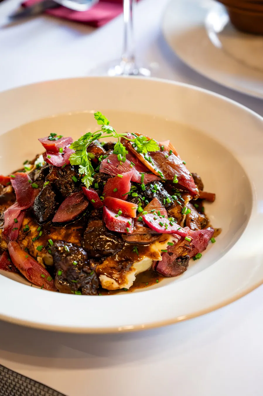 Confit beef cheek on mashed potatoes, red onions and fresh herbs