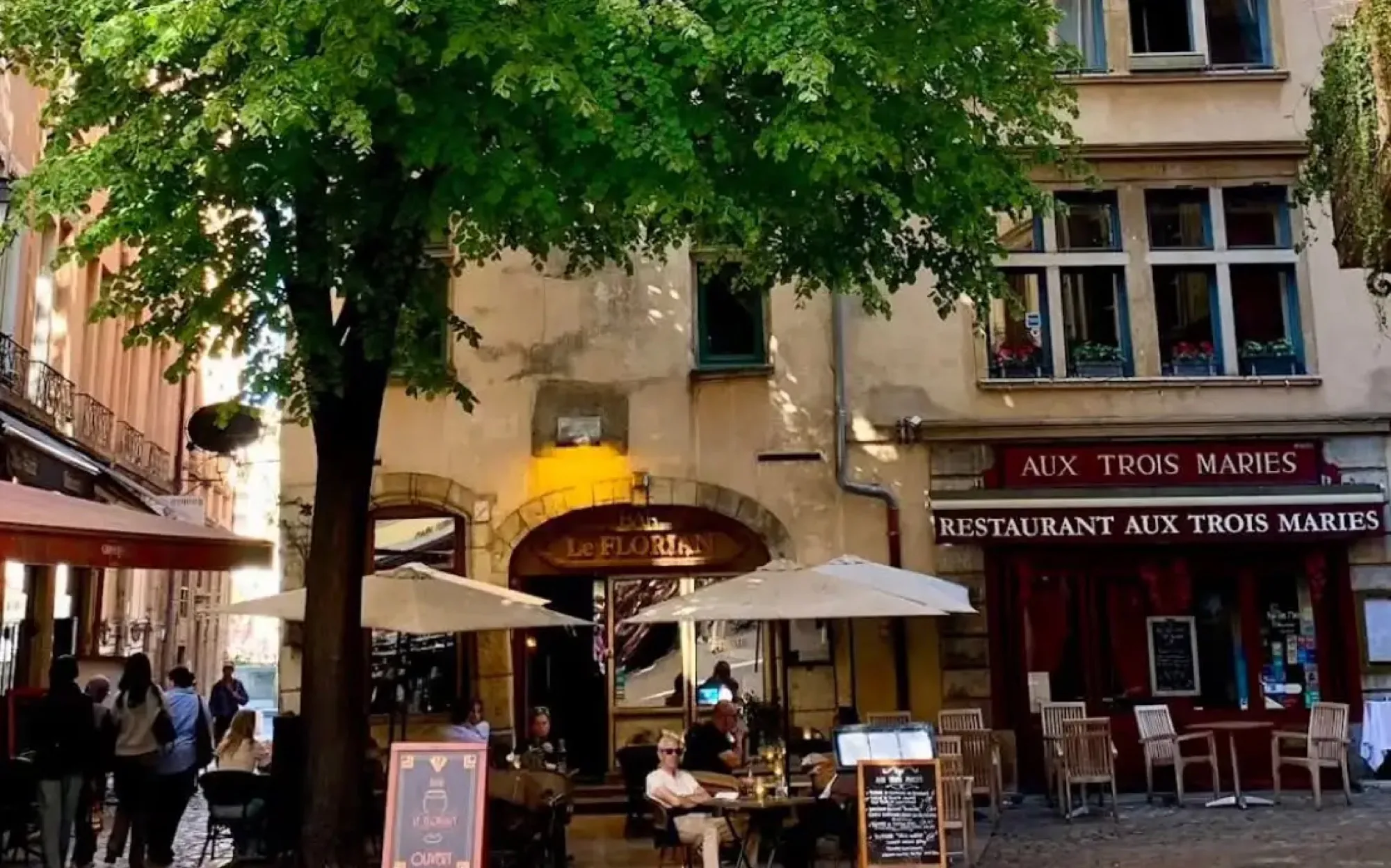 La façade d'Aux Trois Maries et sa terrasse sous le tilleul