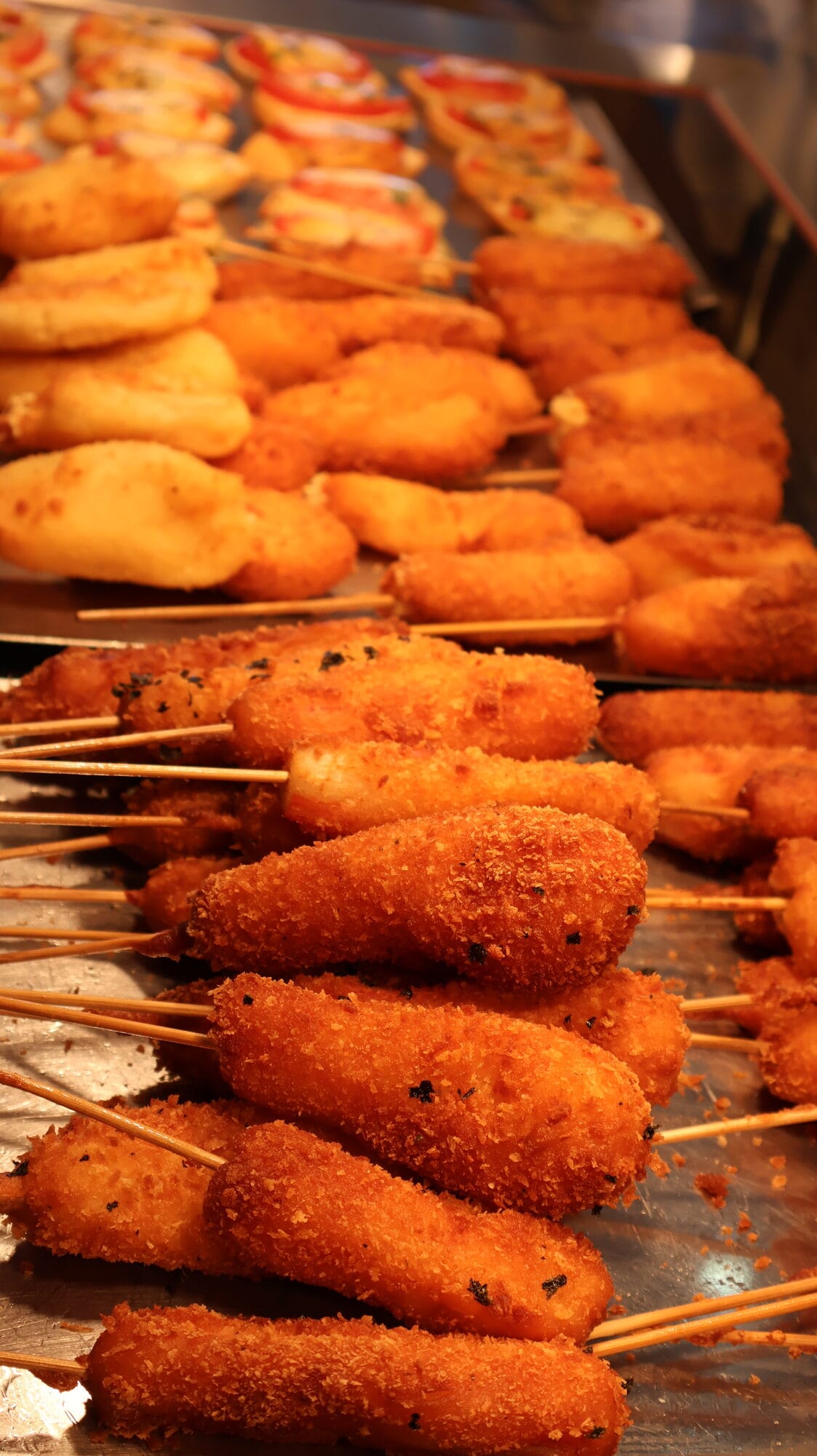 Corn dogs coréens dorés et fritures à partager entre convives lors d'un événement chez GOGI