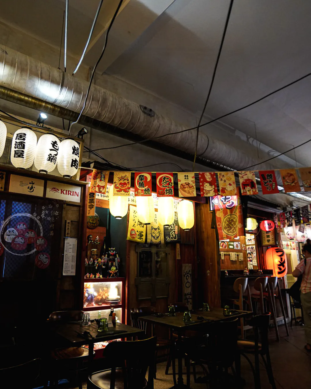 Salle d'Iwao : lanternes izakaya, enseigne Kirin et vitrine de figurines