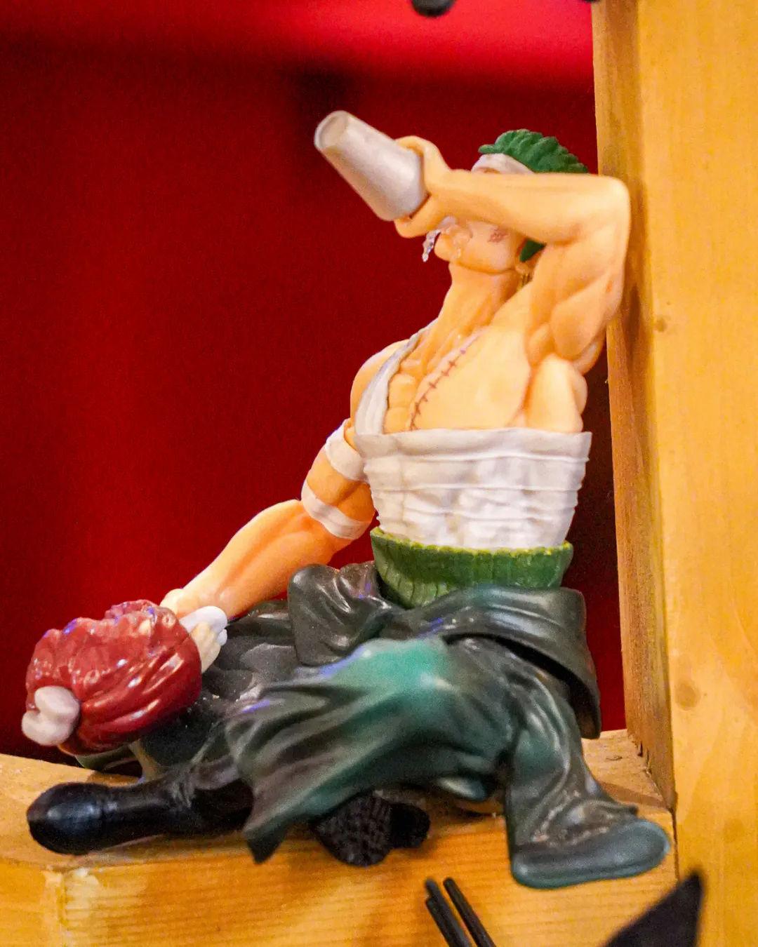 Figurine de héros de manga sur une étagère en bois