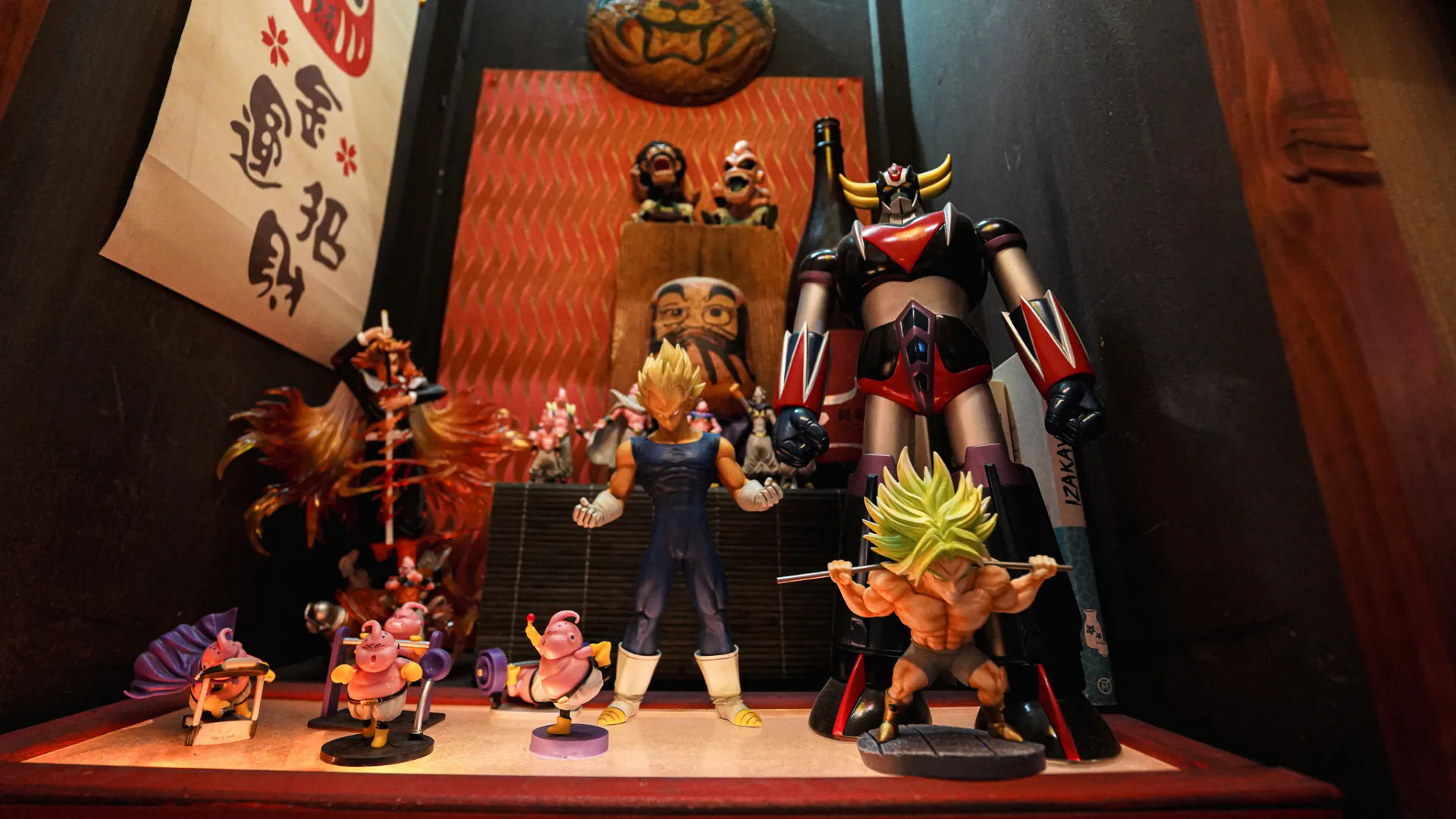 Vitrine de figurines de héros de manga et robots sous un tampon daruma