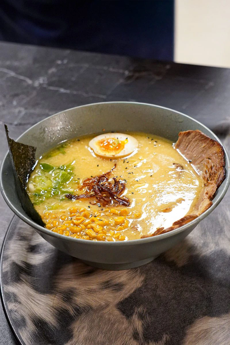 マルセイユの Iwao のカウンターで提供される、黄金色のスープの湯気立つ日本のラーメン