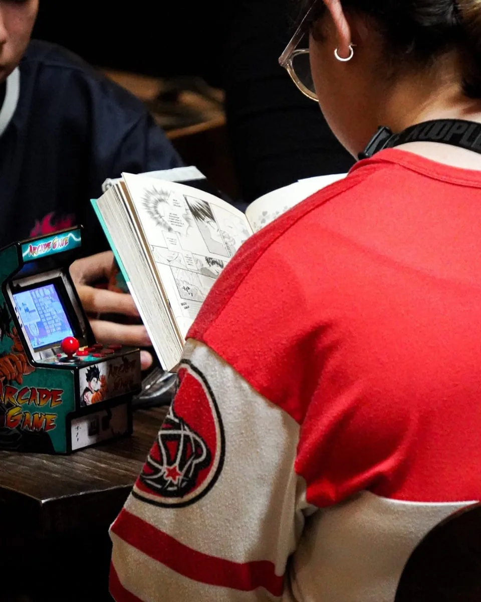 Mini-borne d'arcade et manga lu à table