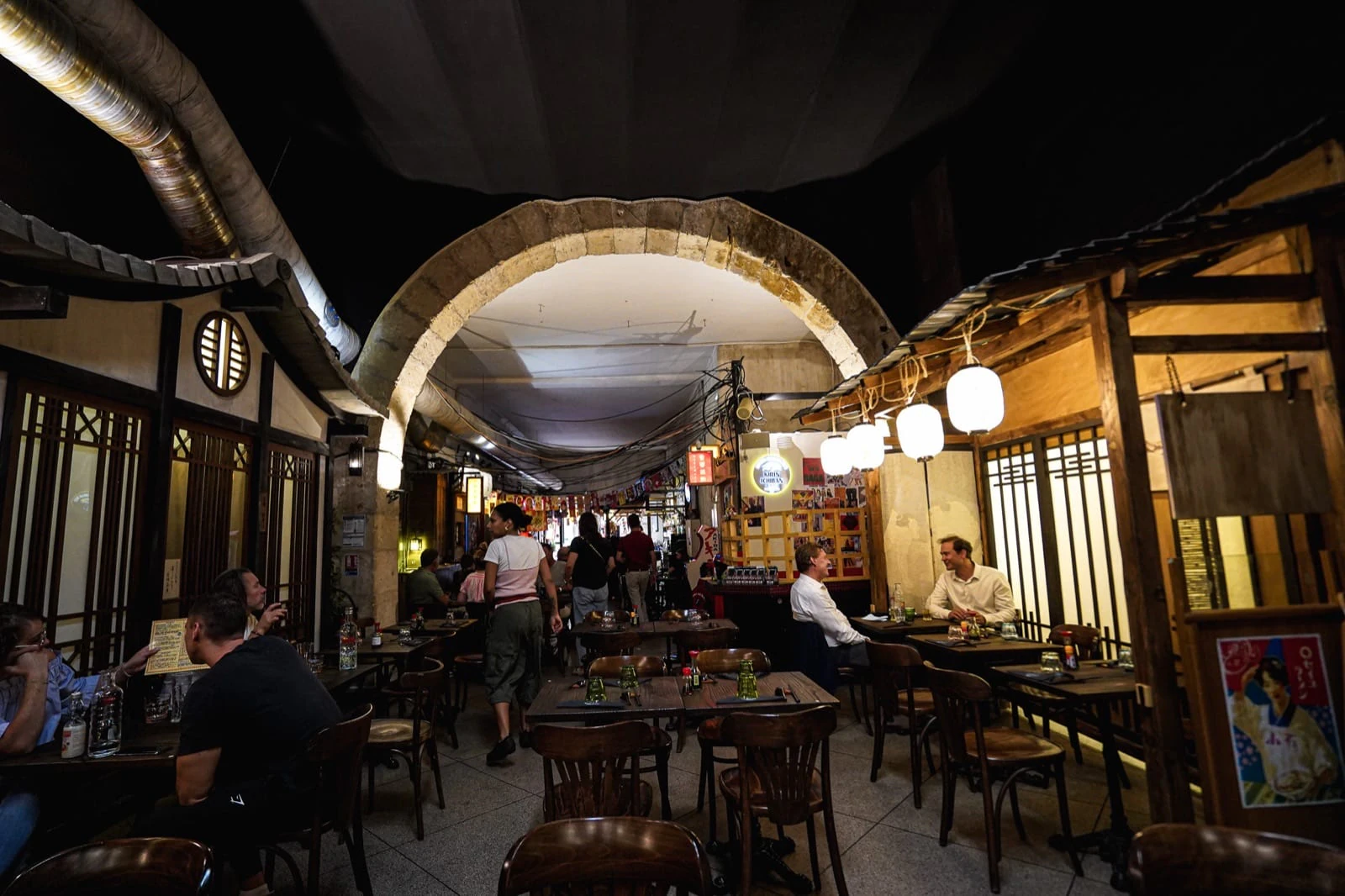 Décor immersif de ruelle japonaise et lanternes rouges dans la salle du restaurant Iwao à Marseille