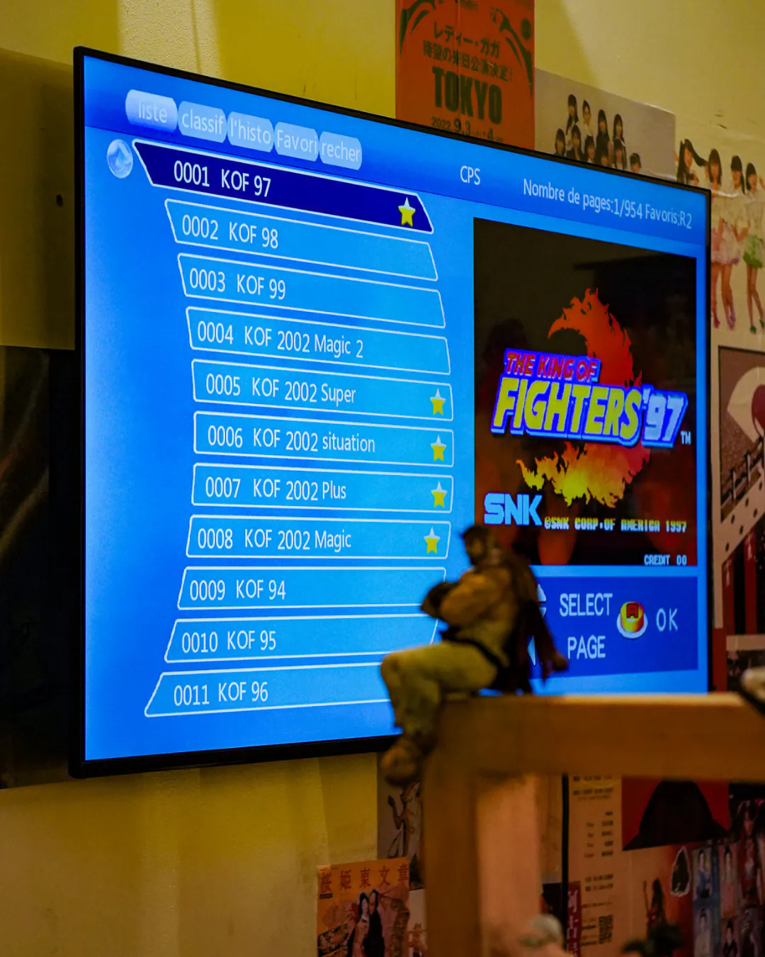 Écran d'arcade de jeu de combat entouré d'affiches japonaises