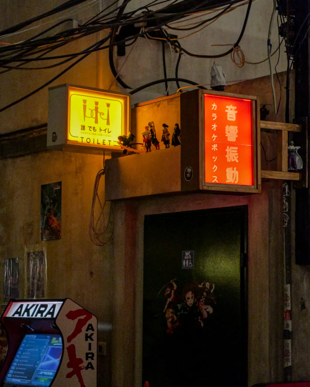 Enseignes lumineuses et borne d'arcade au coin toilettes d'Iwao