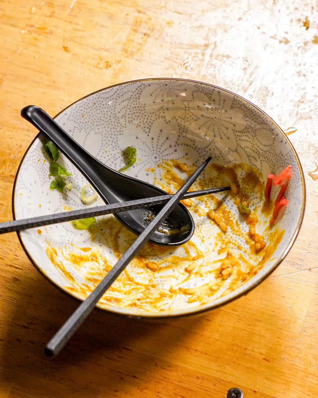 Bol de ramen terminé, cuillère et baguettes posées