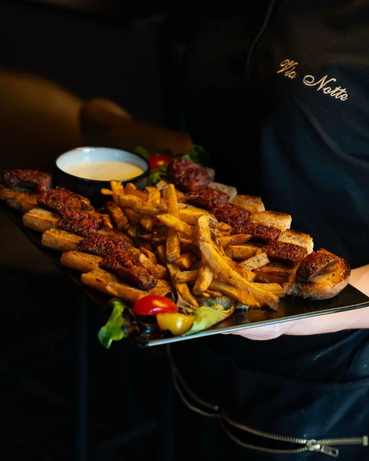 Assiette de viande et frites maison portée en salle