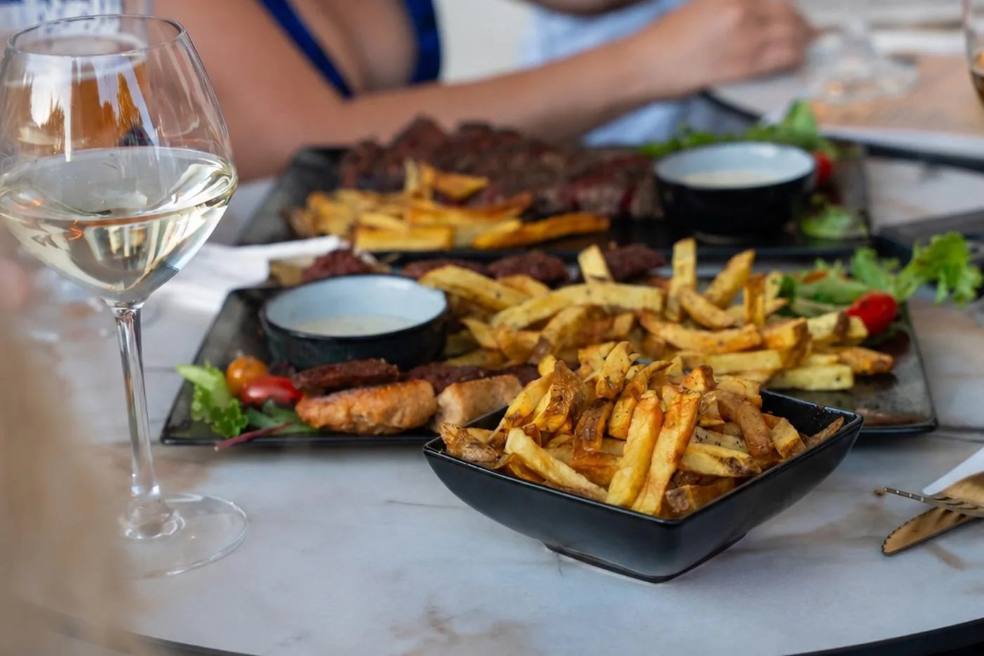 Table dressée avec une planche à partager et un verre de vin blanc