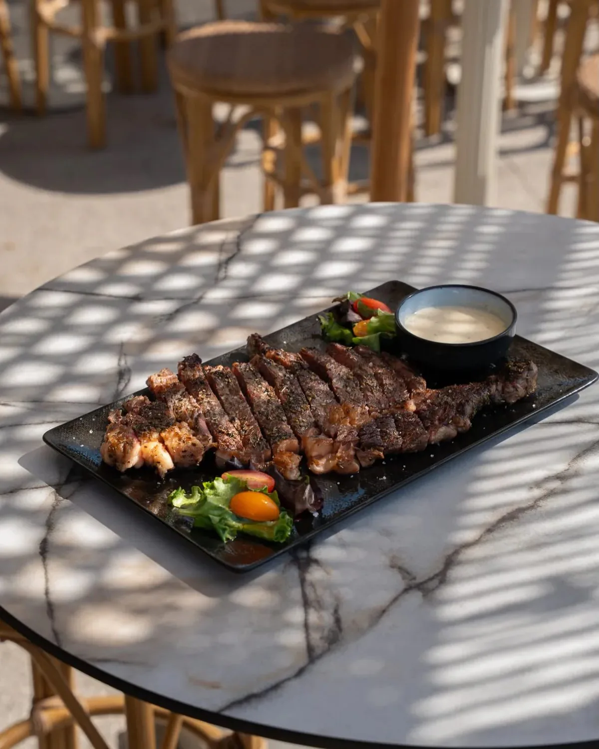 Entrecôte tranchée servie sur ardoise en terrasse