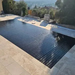 Piscine provençale recouverte d'une bâche à lames pour l'hivernage, bordée d'une terrasse en pierre