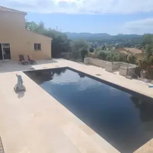 Piscine noire devant une villa provençale surplombant le paysage à l'automne