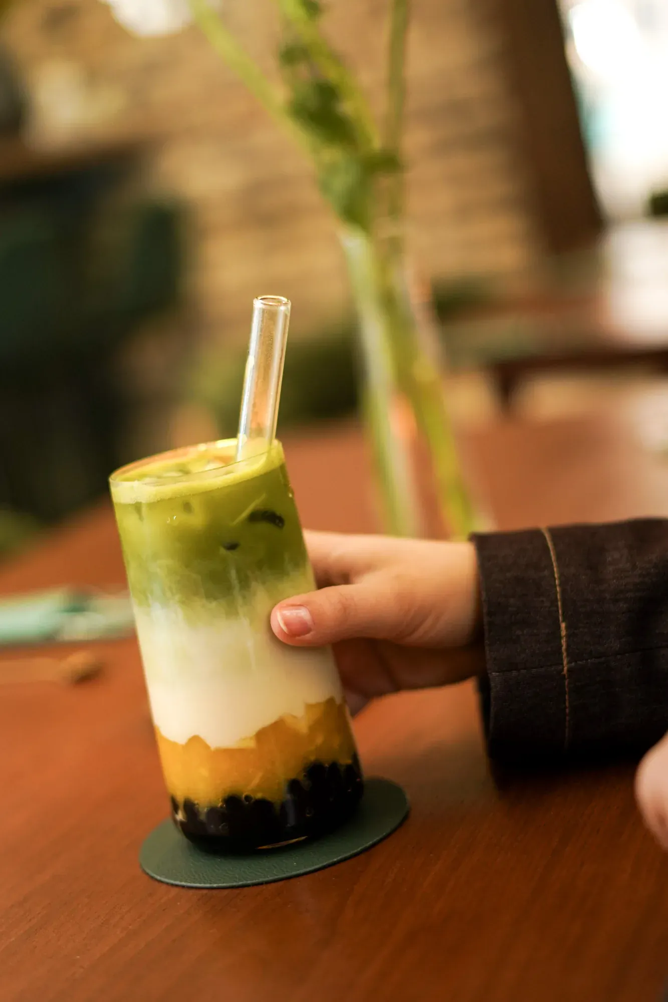 Bubble tea matcha tenu en main, ambiance cosy Le Tê