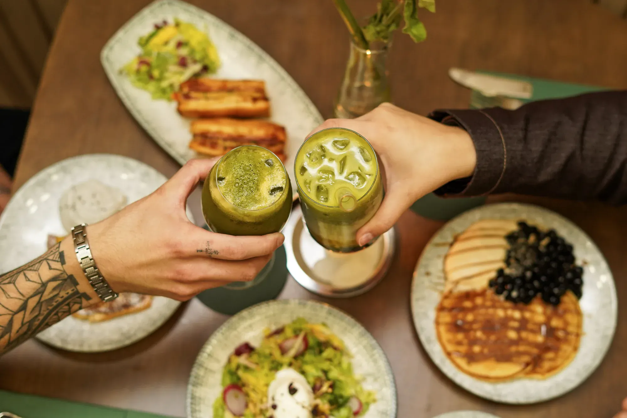 Trinquer avec deux matcha lattes top-down, ambiance partage Le Tê & MAISON LE TÊ