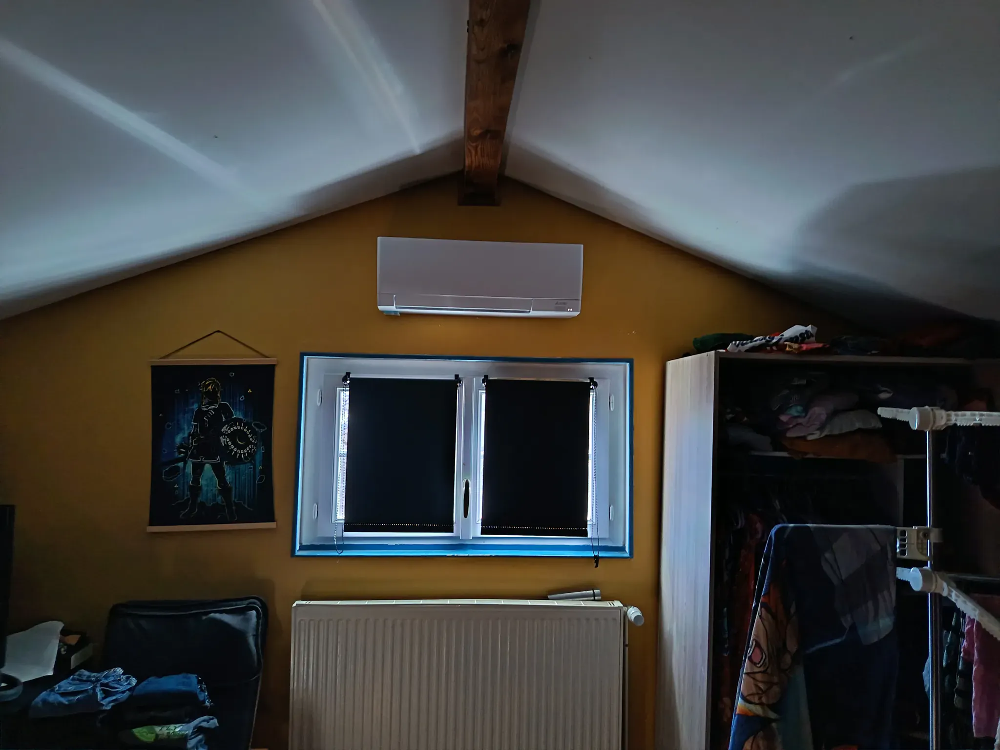 Climatiseur split installé au-dessus d'une fenêtre dans une chambre mansardée près d'Albi