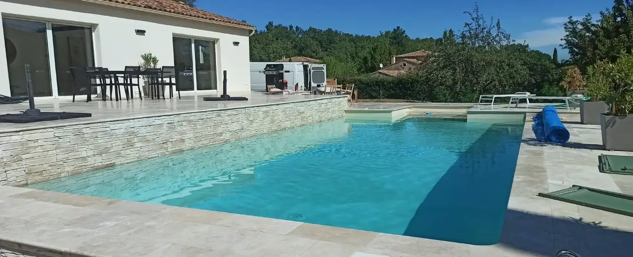 Piscine rénovée avec terrasse surélevée et dallage en travertin