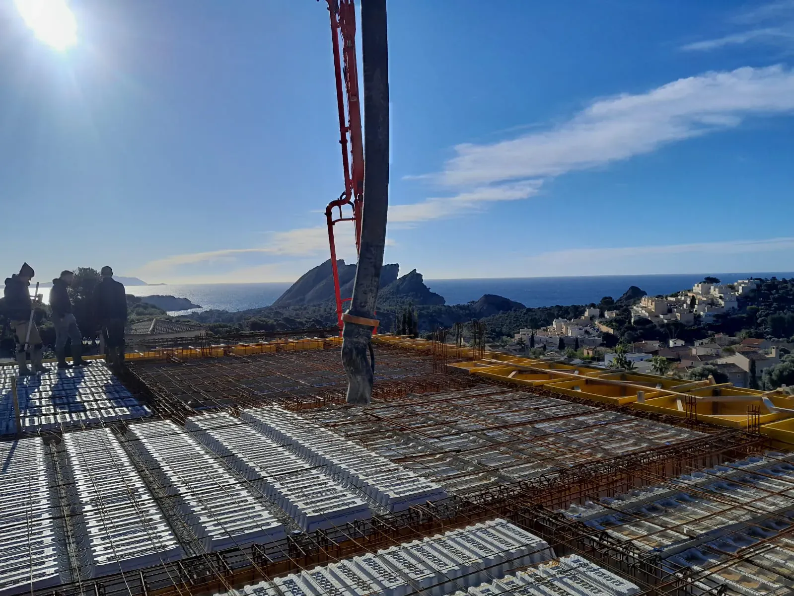 Chantier de gros œuvre coordonné en hauteur avec pompe à béton et ferraillage, vue panoramique