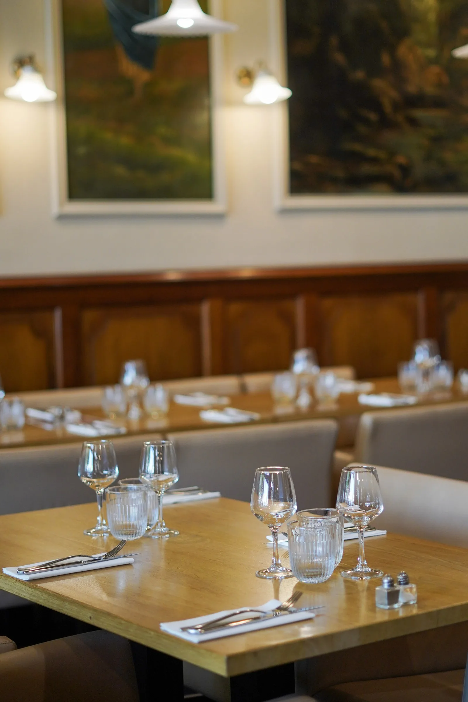 Salle du restaurant Le Saint Martin, tables dressées et banquettes en bois