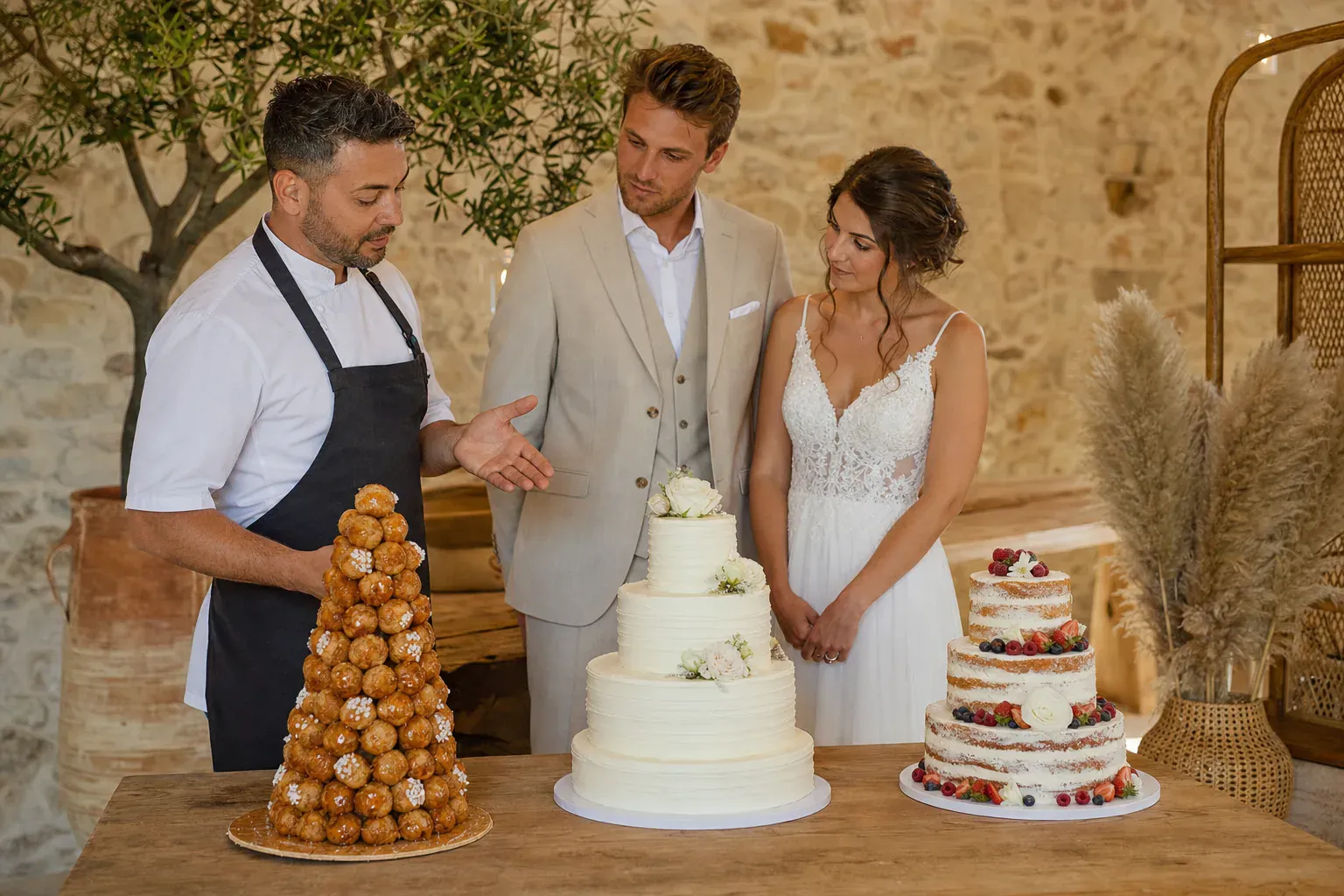 Wedding cake à trois étages jaune orné de roses et des initiales des mariés