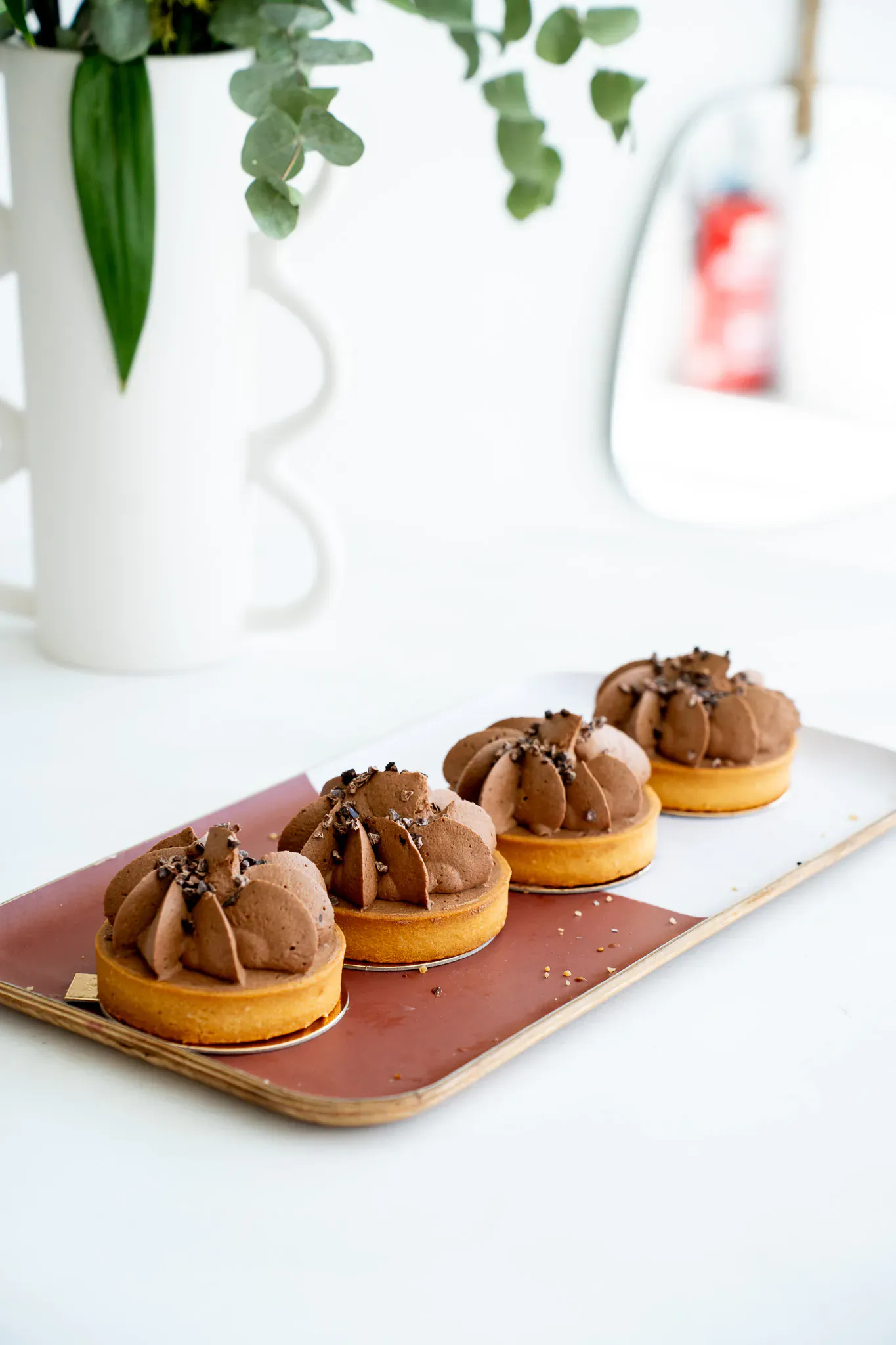 Tartelettes au chocolat garnies de crème fouettée et d'éclats de fèves de cacao