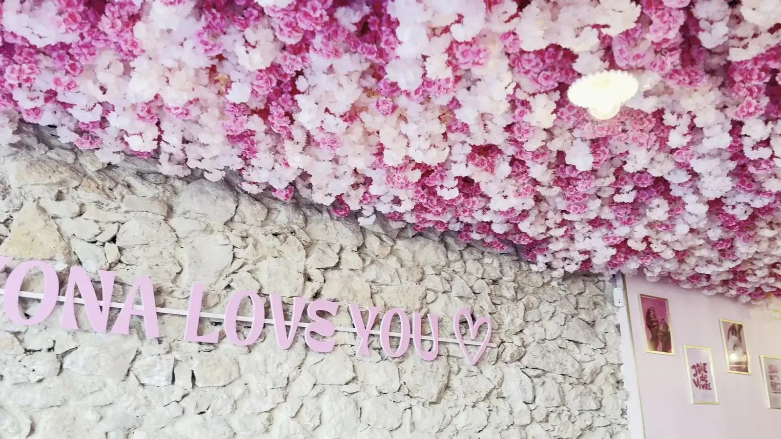 L'écriture rose « Yona loves you » sur le mur en pierre