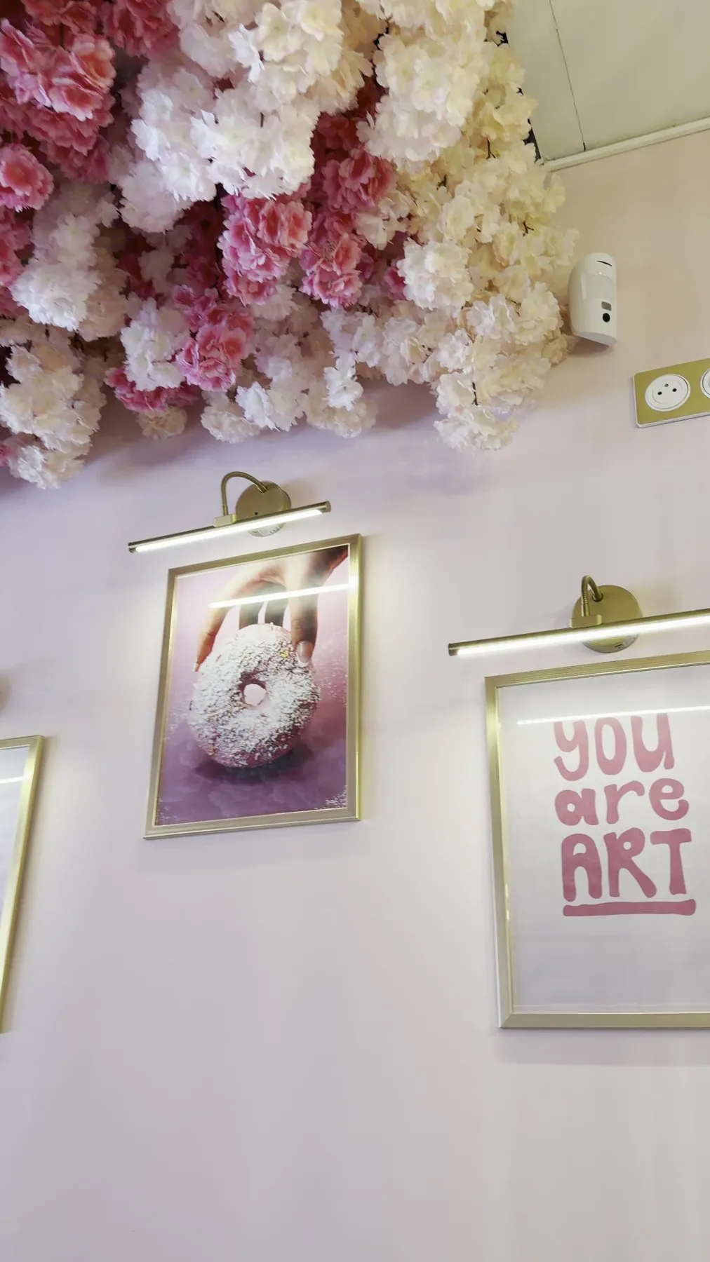 Salle Yona sous un plafond de fleurs roses, banquette et luminaires