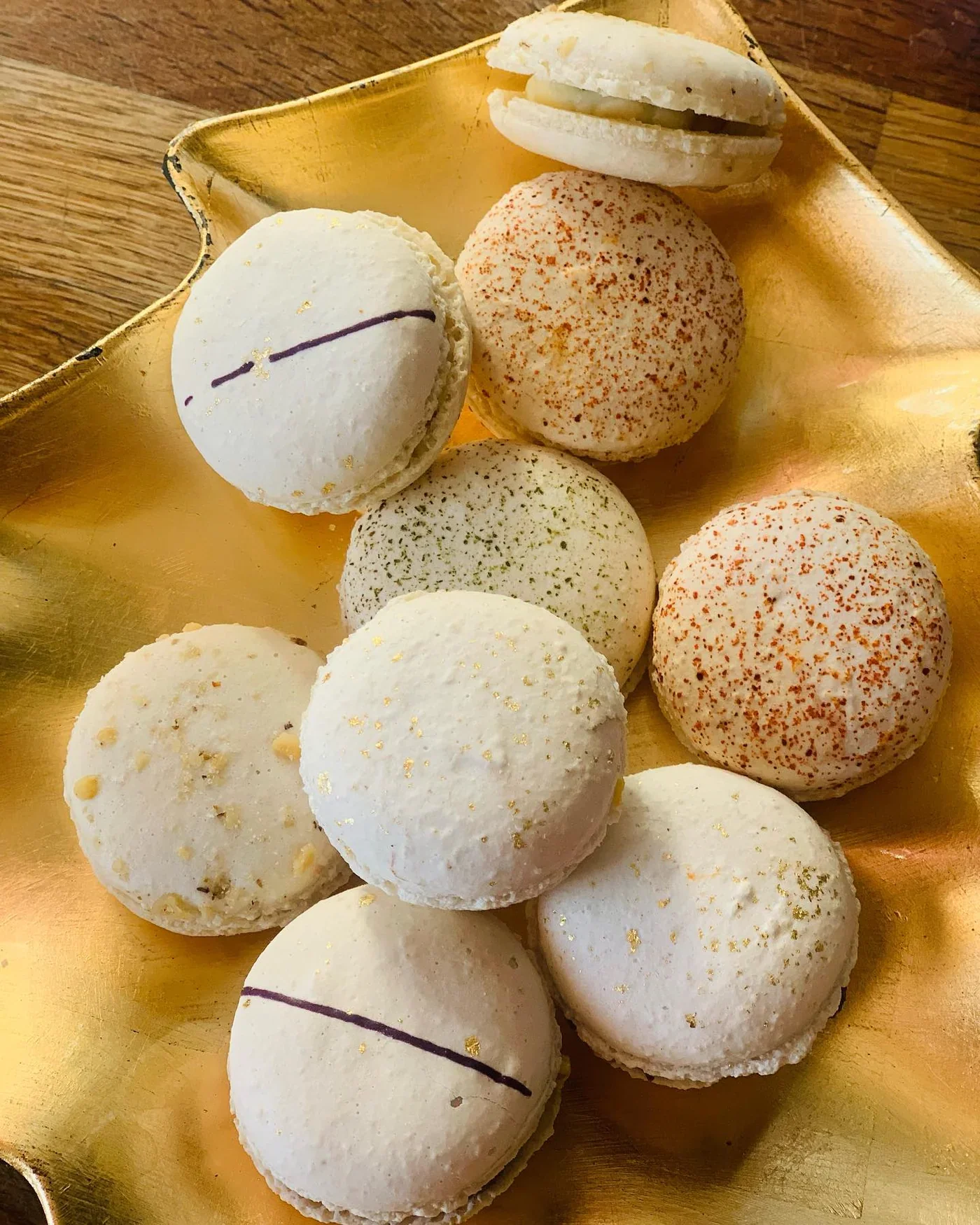 Assortiment de macarons sucrés-salés sur plateau doré, saveurs poivrées, paprika, herbes