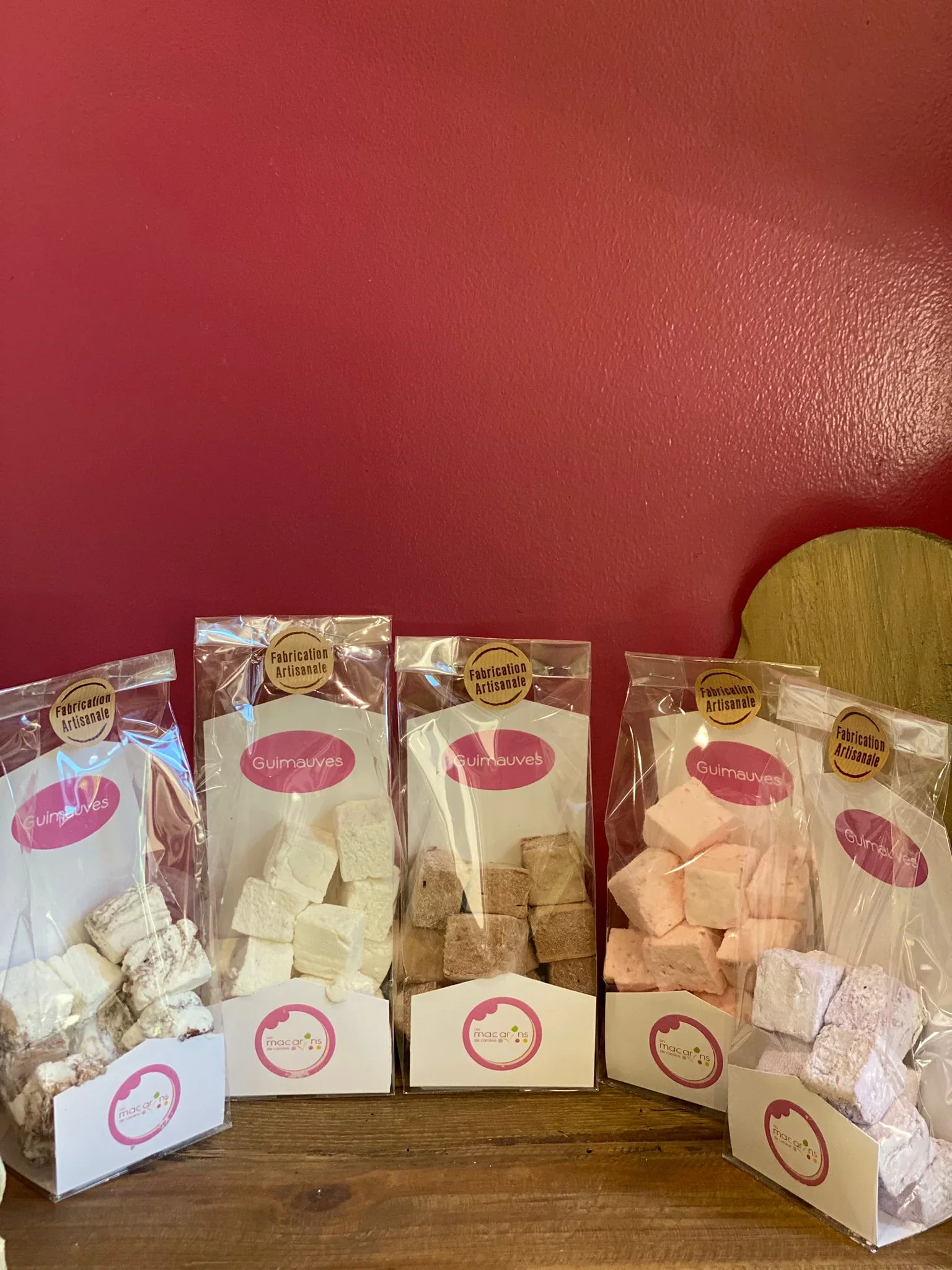 Sachets de guimauves artisanales aux saveurs variées, étiquettes "Fabrication Artisanale" et logo Les Macarons de Caroline