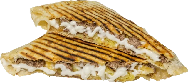 Tacos pressé coupé en deux, garni de viande hachée et de sauce blanche