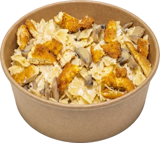 Pâtes farfalle à la sauce crémeuse, champignons et poulet pané, servies en bol kraft à emporter