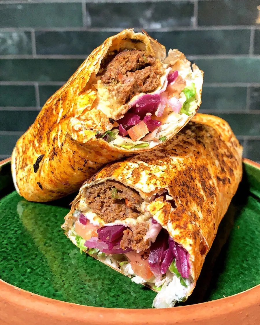 Durum adana viande grillée, coupé, garni d'oignons rouges et de sauce blanche