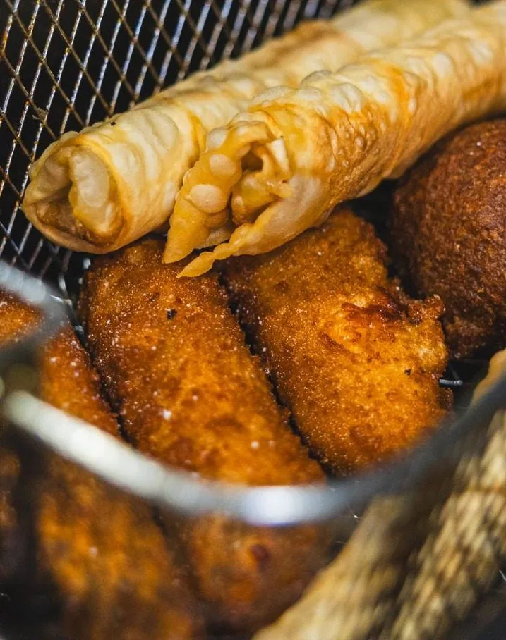Boreks et kebbés dorés sortant du panier de friture