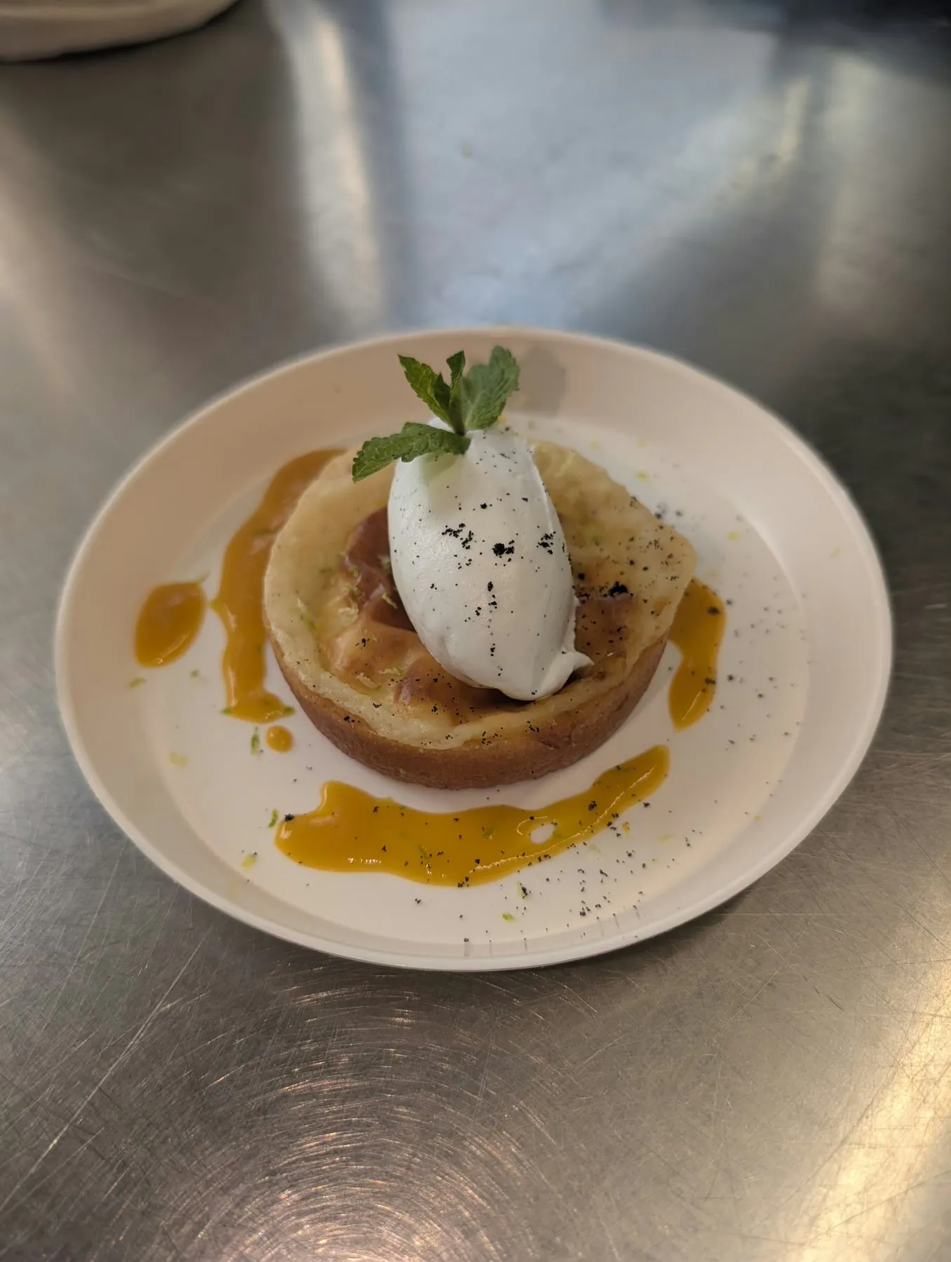 Tartelette, quenelle de crème et coulis de mangue