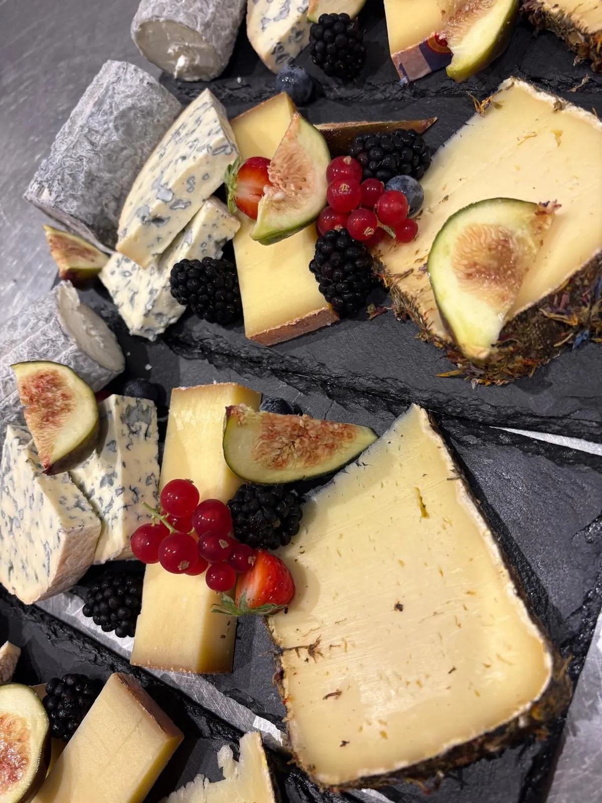 Plateau de fromages affinés sur ardoise, figues et fruits rouges