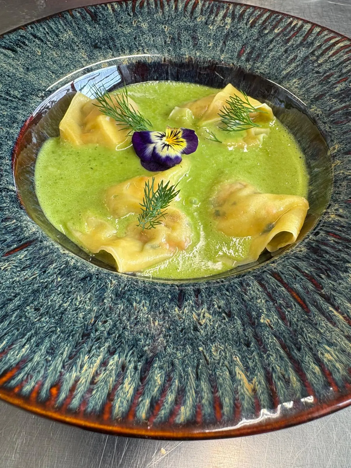 Assiette de raviolis dans une crème verte, dressée pour un dîner d’entreprise