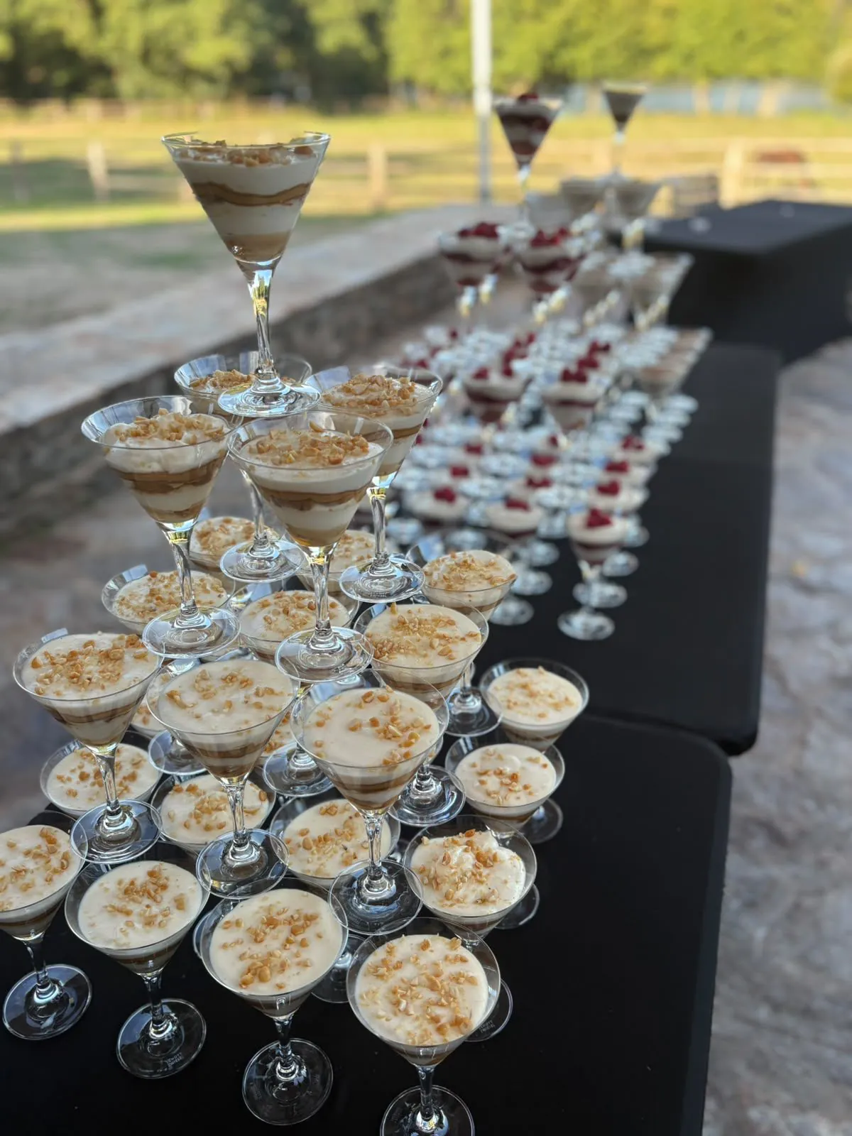 Buffet de desserts en verrines façon verres à martini, garnies de crème et d’éclats croquants