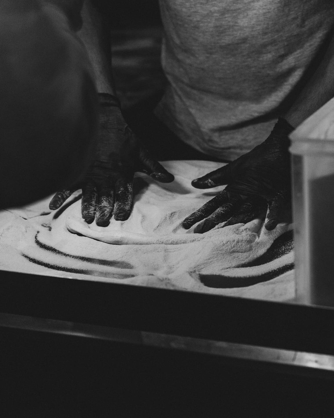 Pizzaiolo working the dough with flour