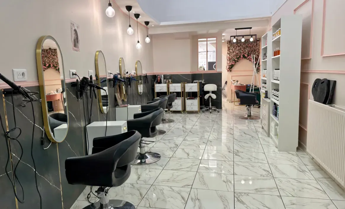 Intérieur du salon de coiffure N Beauty One à Étampes, fauteuils noirs et miroirs dorés