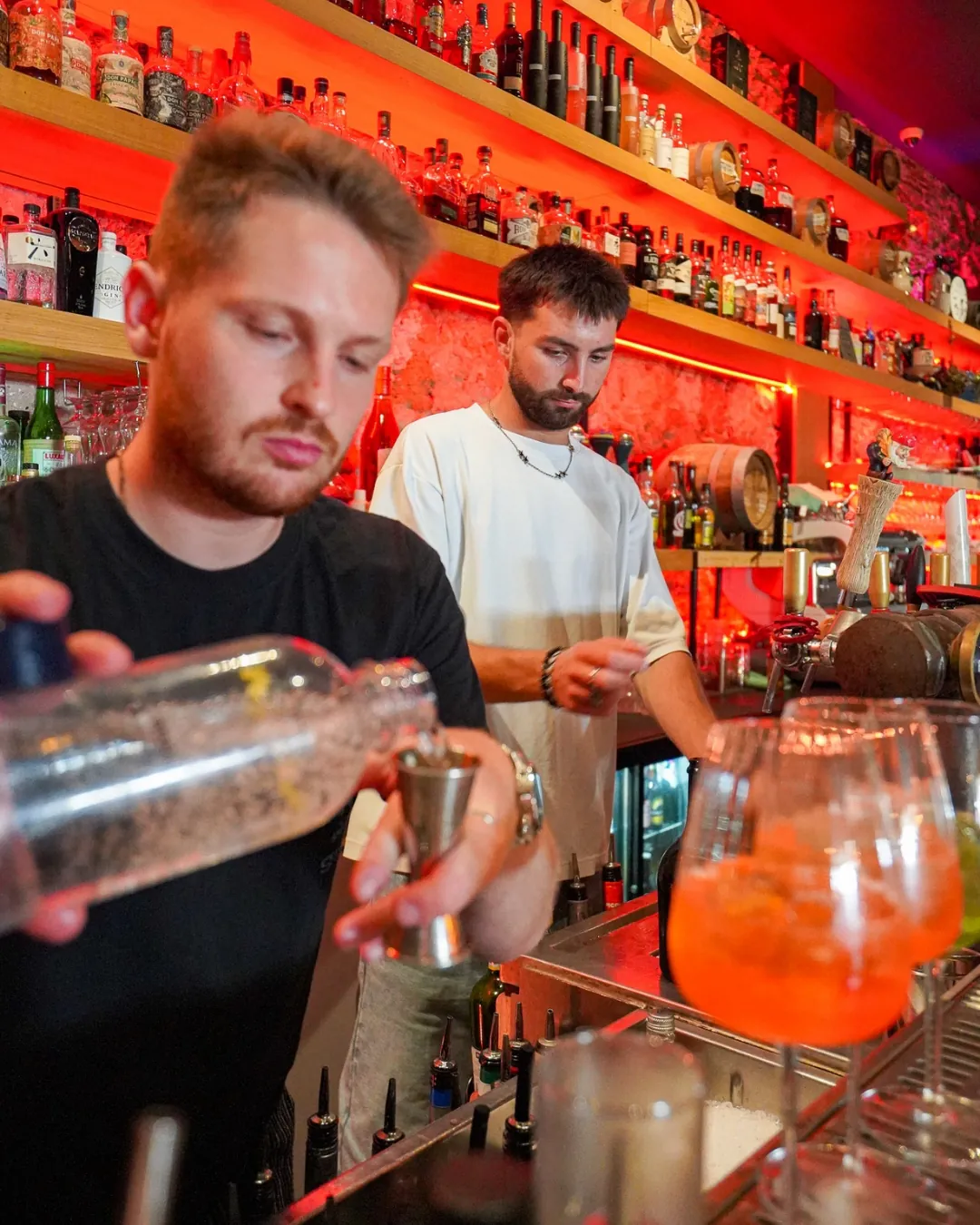 L'équipe du bar du Caribou en action devant le back-bar rouge feu